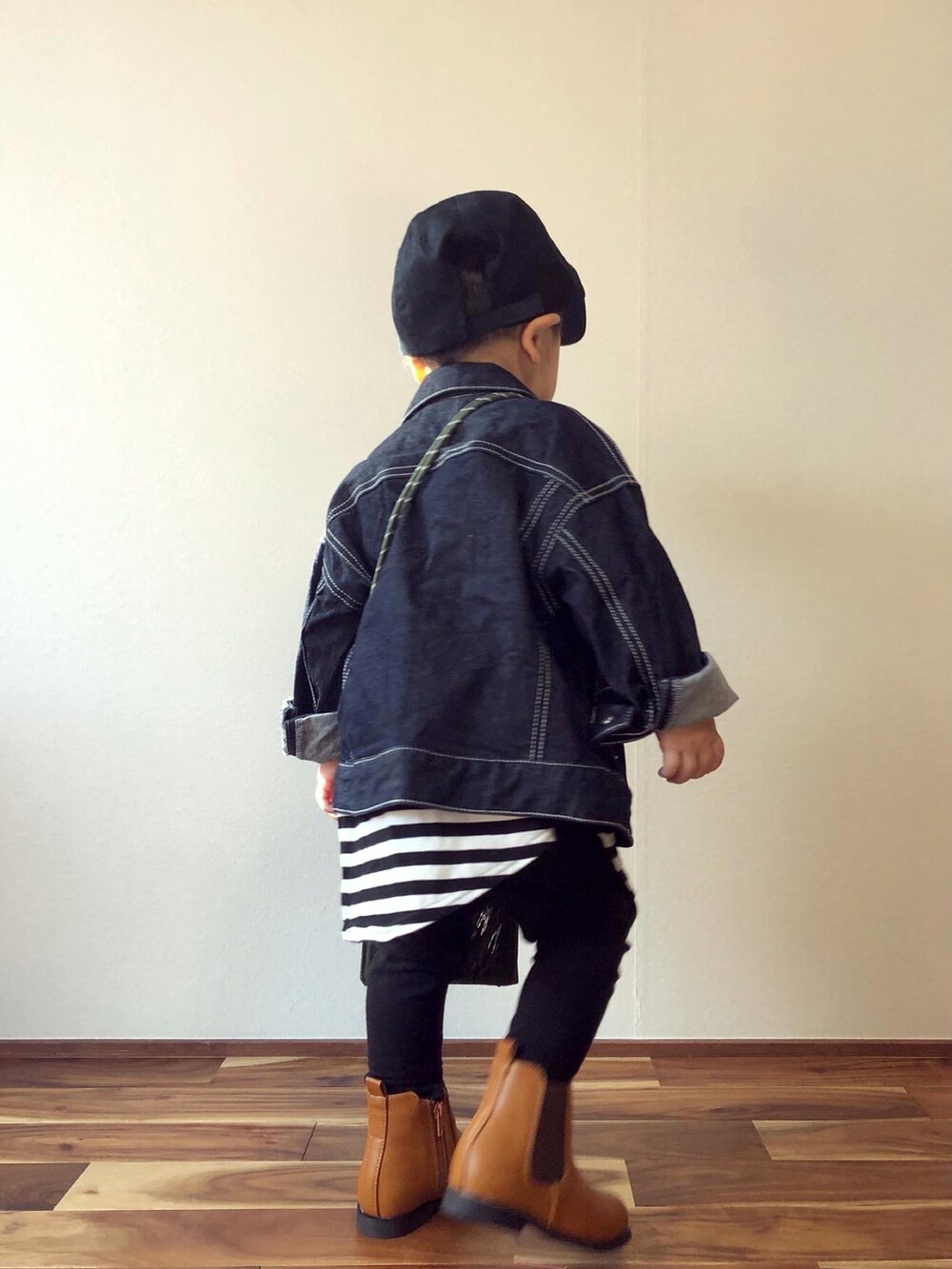 ブルー系のデニムジャケット、ブラック系のTシャツ/カットソー、グリーン系のバッグを着用したキッズの秋コーディネートの3枚目の写真