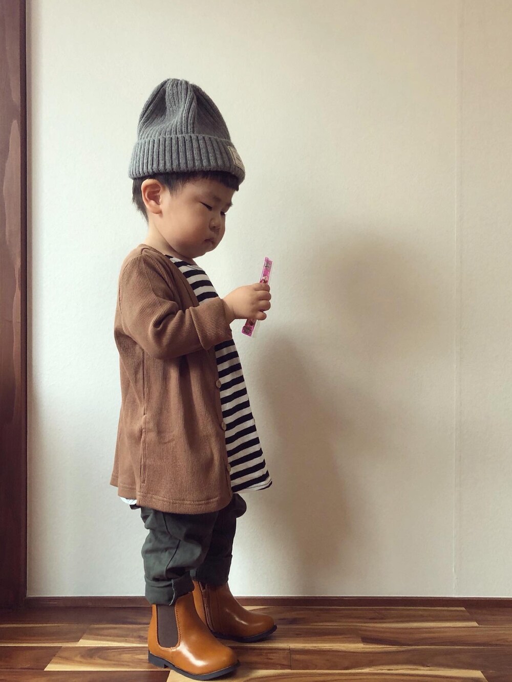 ブラウン系のカーディガン/ボレロ、ブラック系のTシャツ/カットソー、グリーン系のその他パンツを着用したキッズの秋コーディネートの5枚目の写真