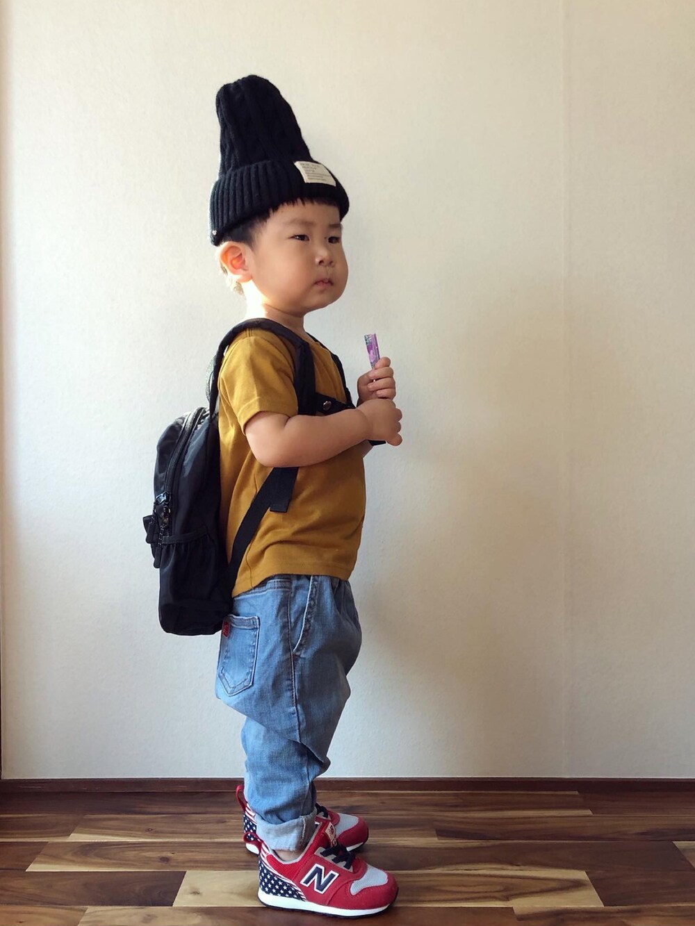 ブラウン系のTシャツ/カットソー、ブラック系のバックパック/リュック、ブルー系のデニムパンツを着用したキッズの秋コーディネートの2枚目の写真