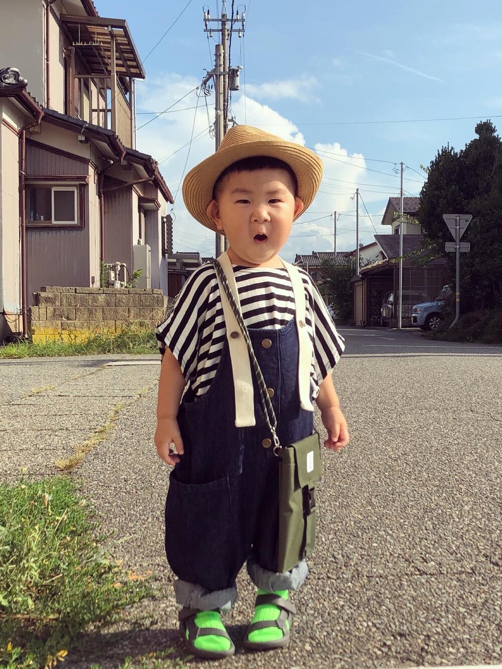 ブラック系のTシャツ/カットソー、ブルー系のサロペット/オーバーオール、グリーン系のバッグを着用したキッズの夏コーディネートの3枚目の写真