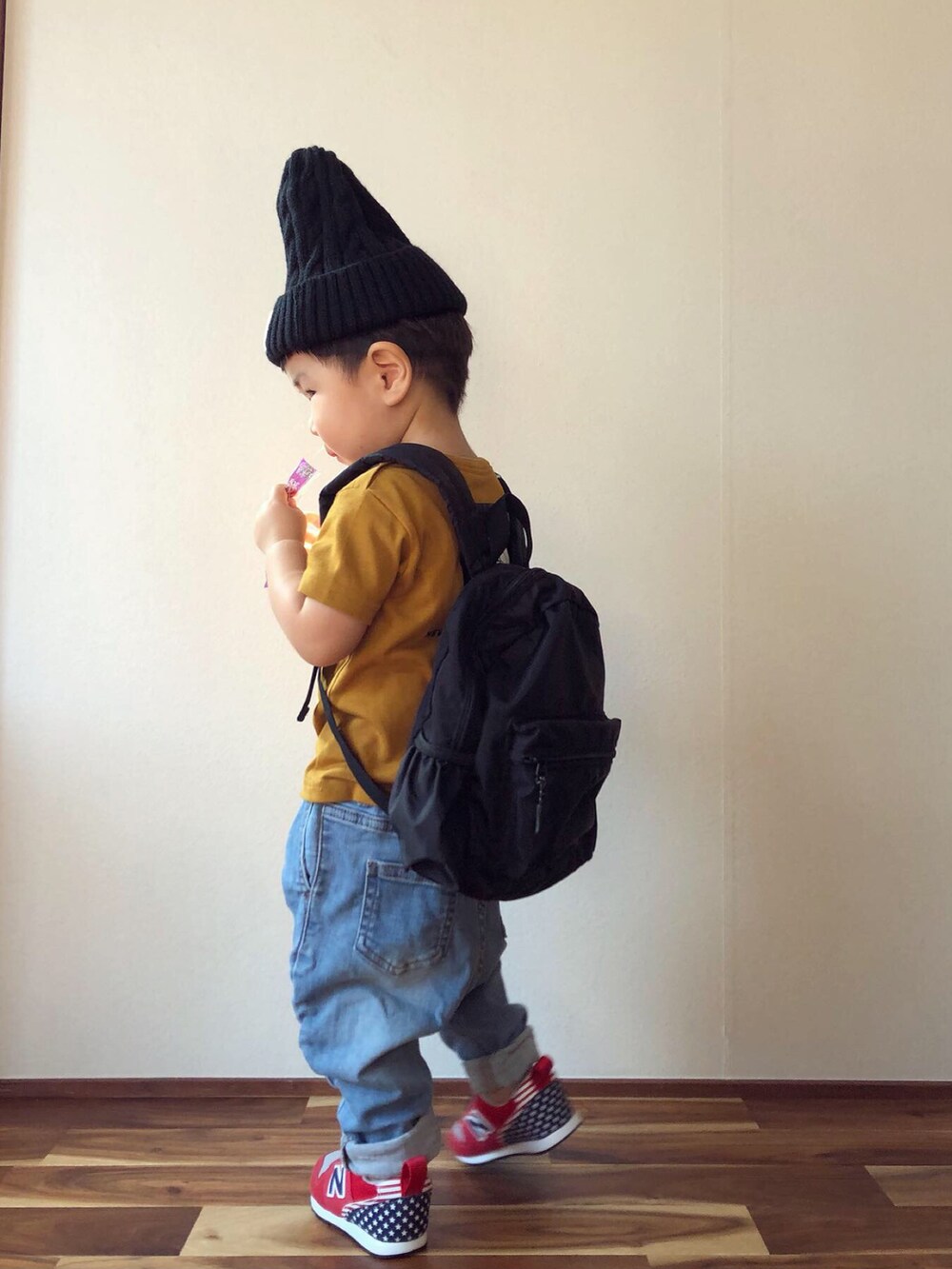 ブラウン系のTシャツ/カットソー、ブラック系のバックパック/リュック、ブルー系のデニムパンツを着用したキッズの秋コーディネートの4枚目の写真