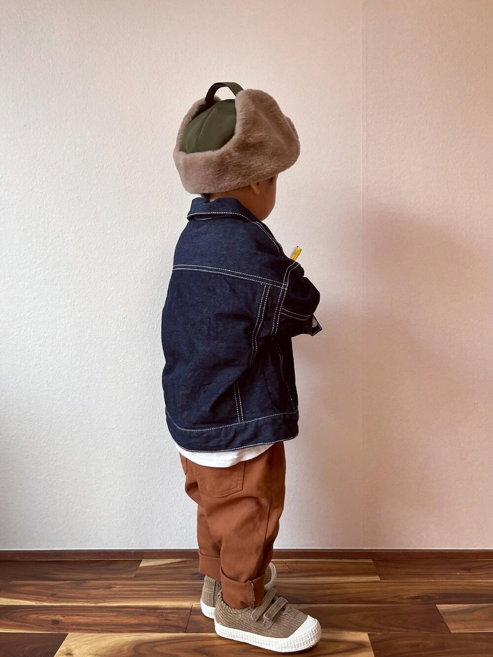 ブルー系のデニムジャケット、ブラック系のスウェット、イエロー系のその他パンツを着用したキッズの秋コーディネートの2枚目の写真