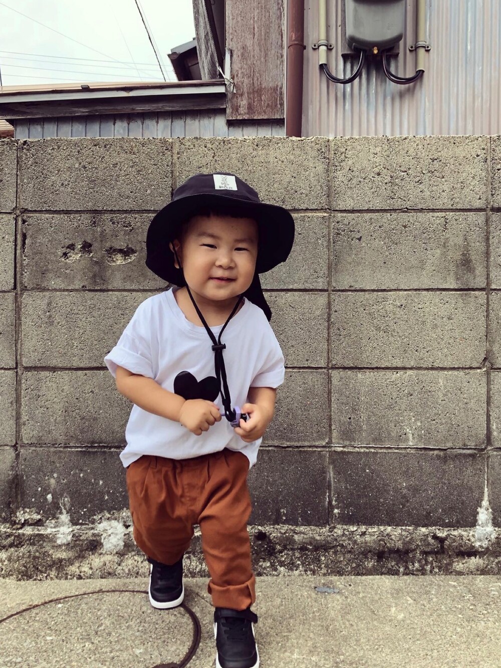 ホワイト系のTシャツ/カットソー、イエロー系のその他パンツ、ブラック系のスニーカーを着用したキッズの夏コーディネートの4枚目の写真