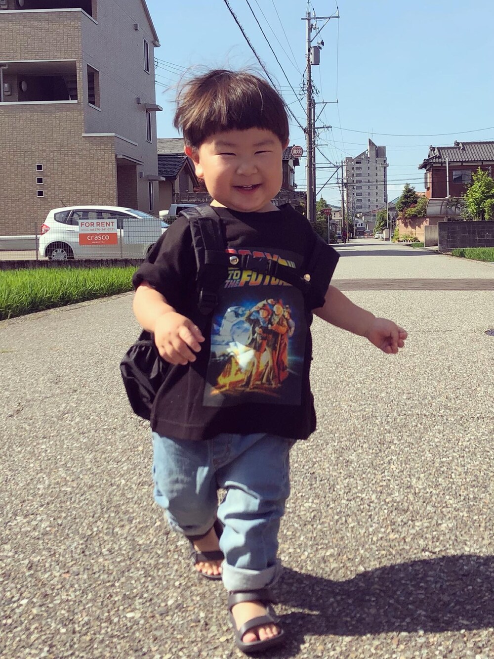 ブラック系のTシャツ/カットソー、ブルー系のデニムパンツ、グレー系のサンダルを着用したキッズの夏コーディネートの2枚目の写真