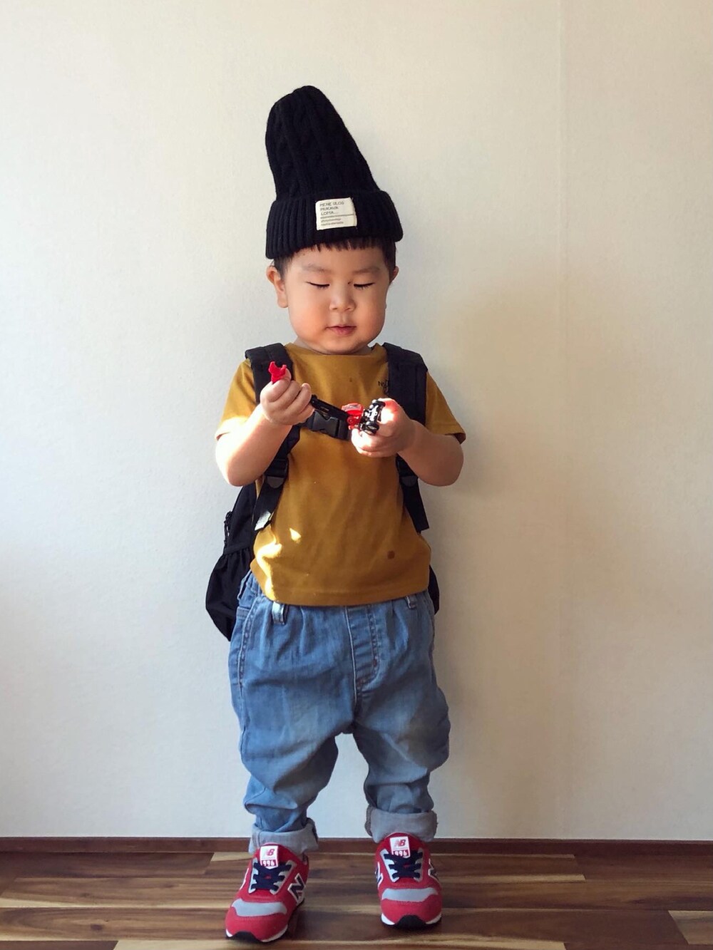 ブラウン系のTシャツ/カットソー、ブラック系のバックパック/リュック、ブルー系のデニムパンツを着用したキッズの秋コーディネートの5枚目の写真