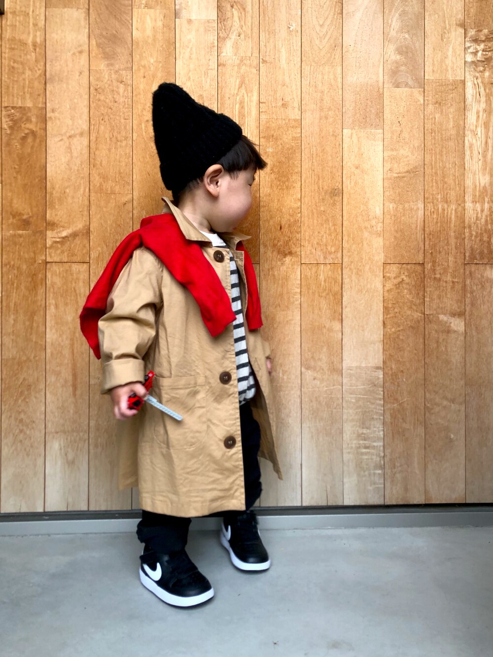 ホワイト系のスウェット、ベージュ系のステンカラーコート、レッド系のカーディガン/ボレロを着用したキッズの春コーディネートの2枚目の写真