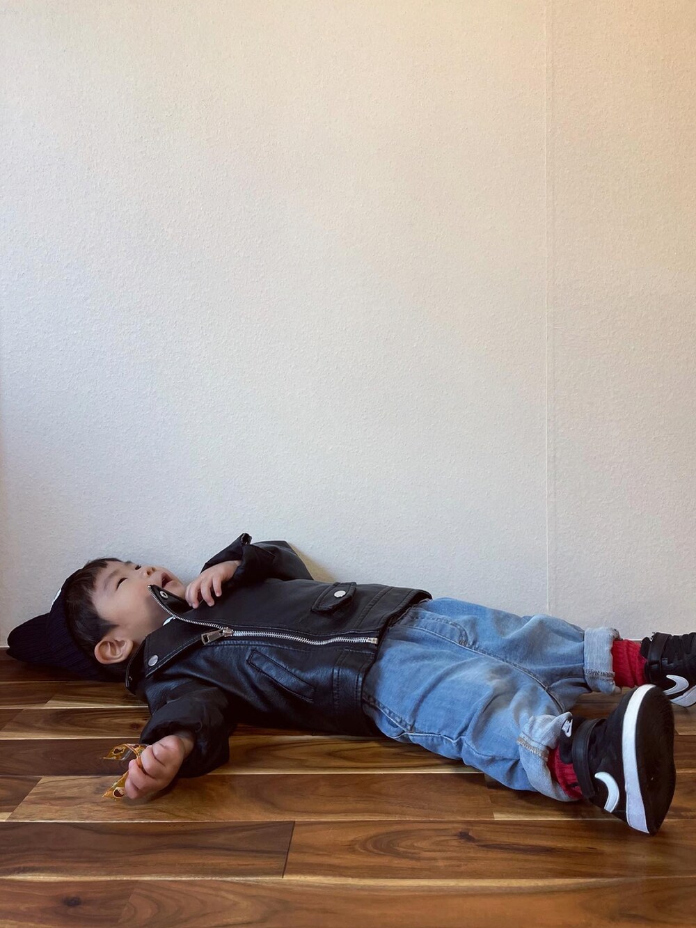 ブラック系のライダースジャケット、ブルー系のデニムパンツ、ブラック系のスニーカーを着用したキッズの秋コーディネートの4枚目の写真