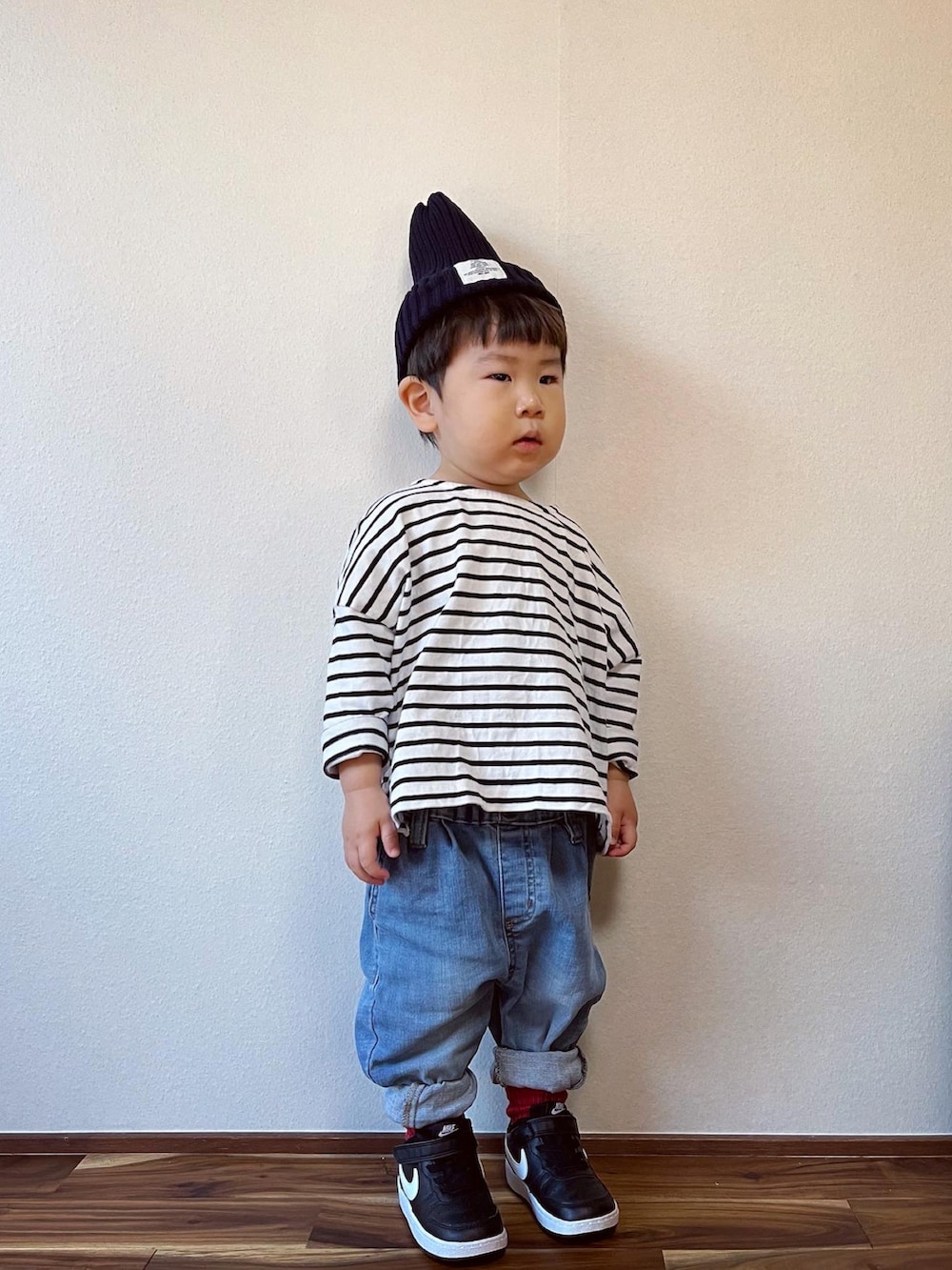 ブラック系のTシャツ/カットソー、ブルー系のデニムパンツ、ブラック系のスニーカーを着用したキッズの秋コーディネートの3枚目の写真