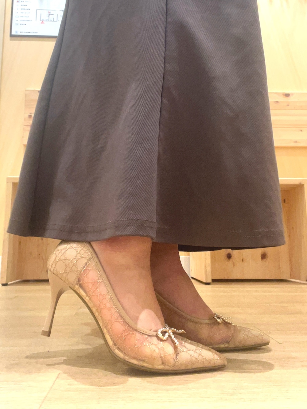 ゴールド系のパンプスを着用したレディースの春コーディネートの2枚目の写真