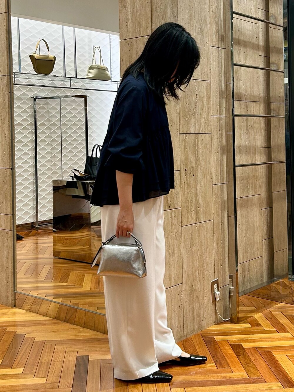 グレー系のTシャツ/カットソー、ホワイト系のその他パンツ、シルバー系のハンドバッグを着用したレディースの秋コーディネートの2枚目の写真