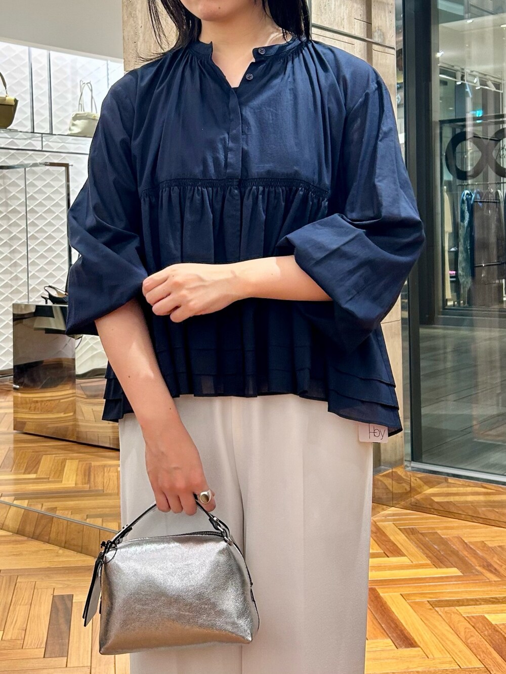 グレー系のTシャツ/カットソー、ホワイト系のその他パンツ、シルバー系のハンドバッグを着用したレディースの秋コーディネートの4枚目の写真