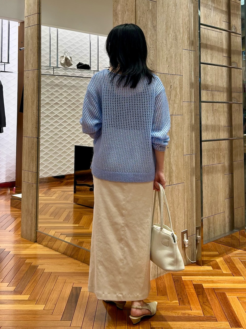 ホワイト系のトートバッグ、ホワイト系のスカート、ブルー系のニット/セーターを着用したレディースの秋コーディネートの3枚目の写真