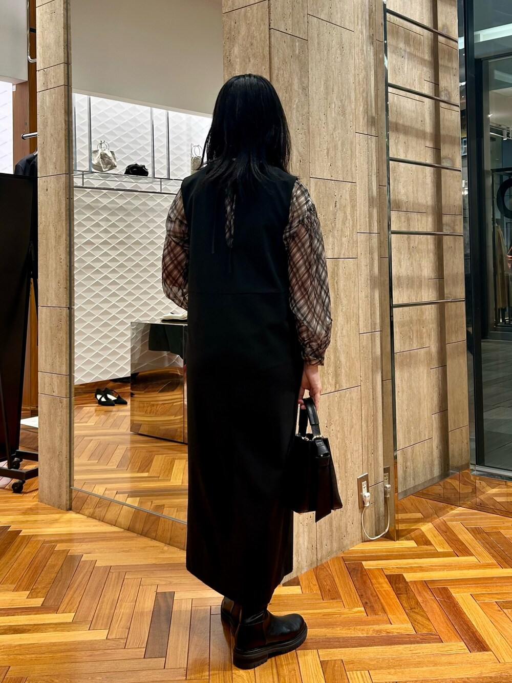 ブラック系のシャツ/ブラウス、ブラック系のワンピース、ブラック系のハンドバッグを着用したレディースの秋コーディネートの3枚目の写真
