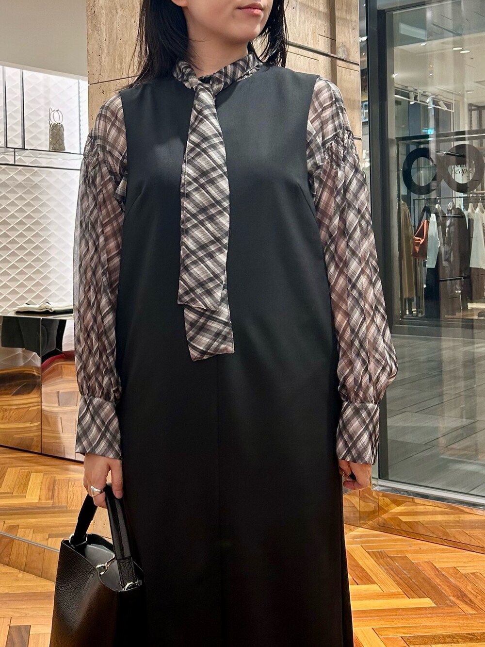 ブラック系のシャツ/ブラウス、ブラック系のワンピース、ブラック系のハンドバッグを着用したレディースの秋コーディネートの4枚目の写真