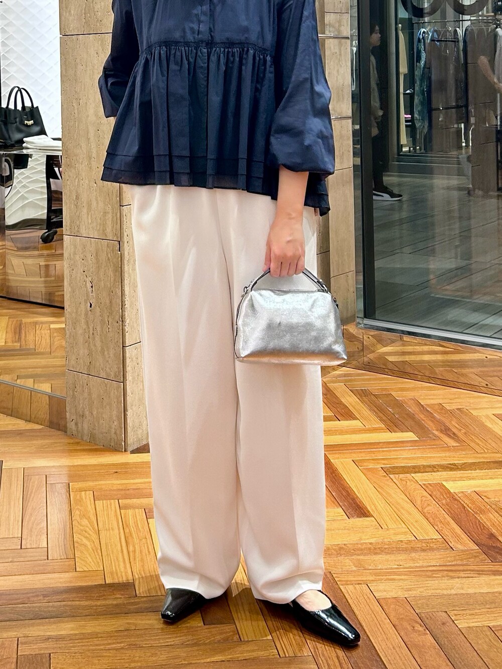 グレー系のTシャツ/カットソー、ホワイト系のその他パンツ、シルバー系のハンドバッグを着用したレディースの秋コーディネートの5枚目の写真
