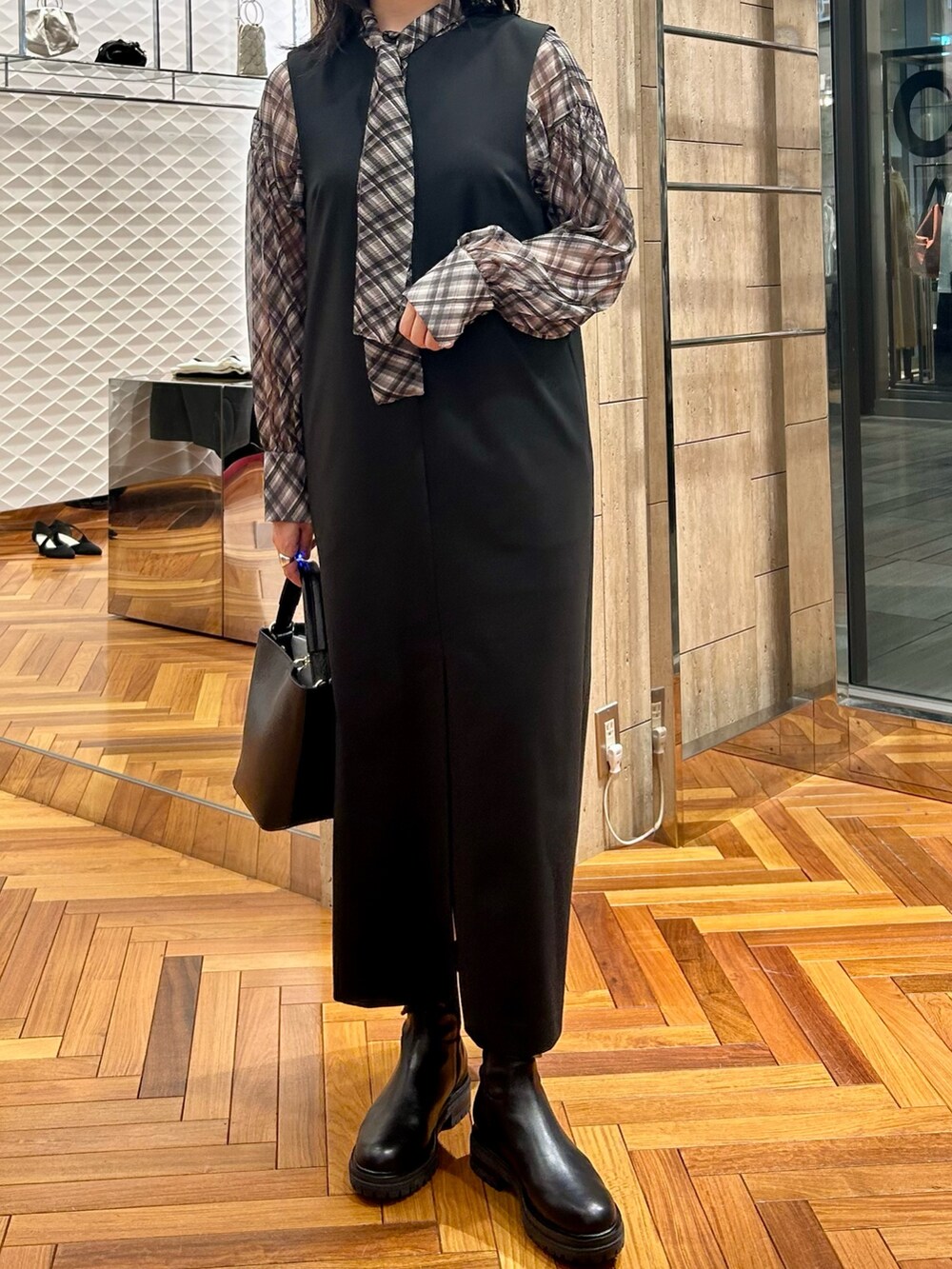 ブラック系のシャツ/ブラウス、ブラック系のワンピース、ブラック系のハンドバッグを着用したレディースの秋コーディネートの5枚目の写真