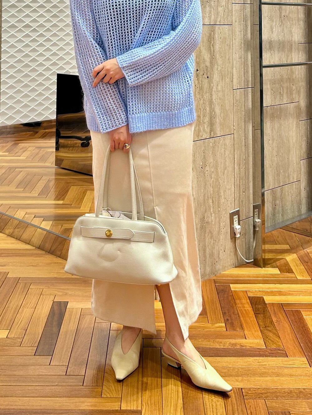 ホワイト系のトートバッグ、ホワイト系のスカート、ブルー系のニット/セーターを着用したレディースの秋コーディネートの5枚目の写真