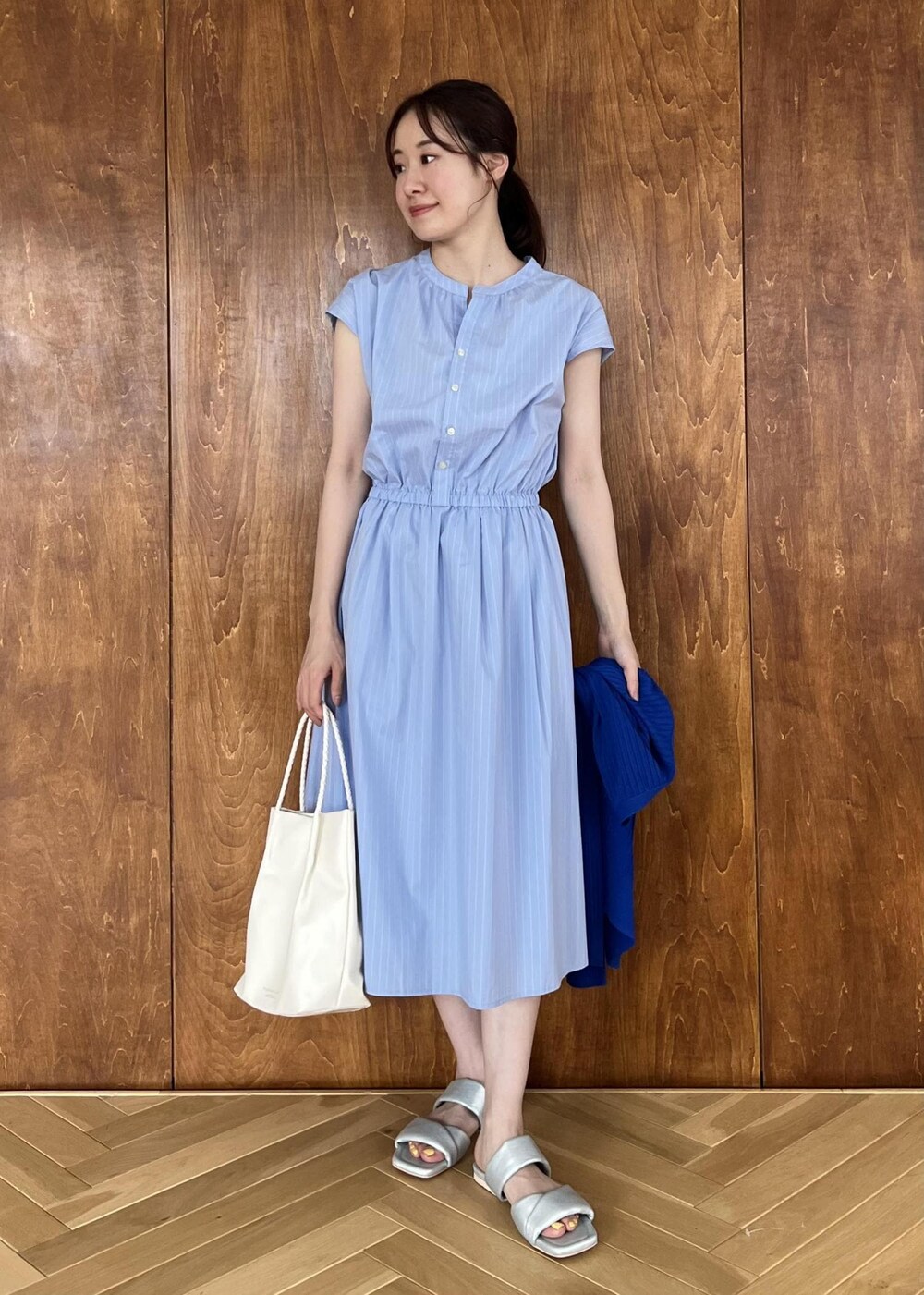 シルバー系のサンダル、ブルー系のカーディガン/ボレロ、ホワイト系のトートバッグを着用したレディースの夏コーディネートの4枚目の写真