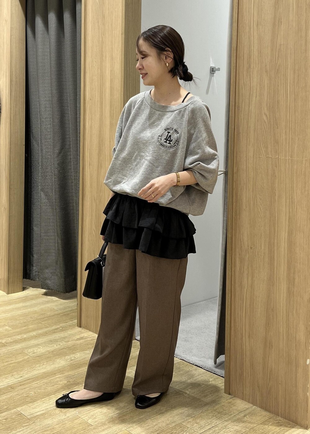 ブラック系のショルダーバッグ、ブラック系のキャミソール、グレー系のスウェットを着用したレディースの秋コーディネートの6枚目の写真