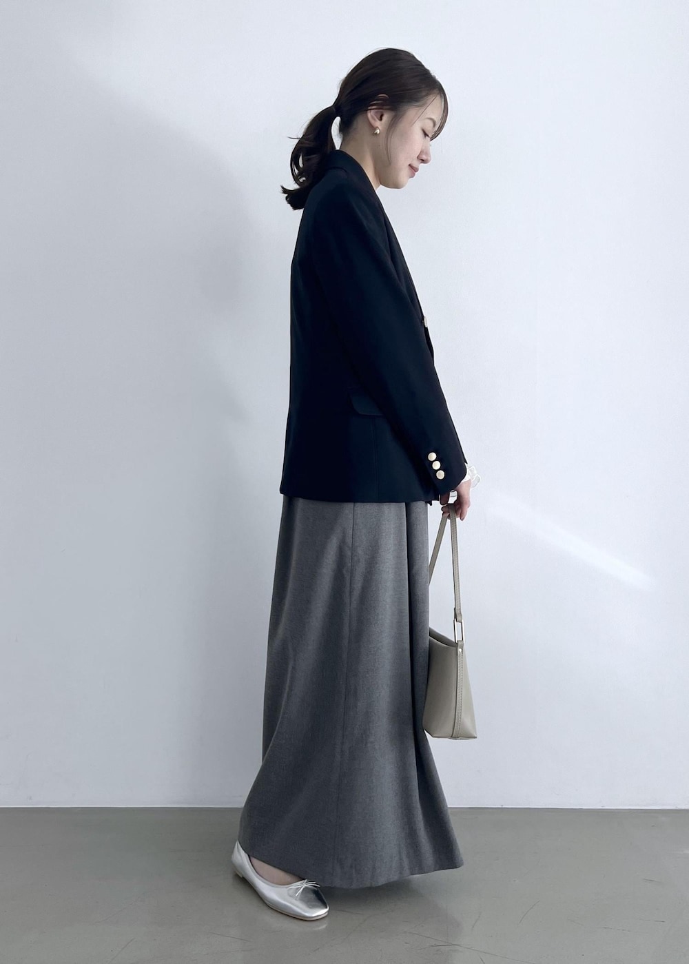 ホワイト系のTシャツ/カットソー、グレー系のワンピース、ベージュ系のショルダーバッグを着用したレディースの冬コーディネートの2枚目の写真