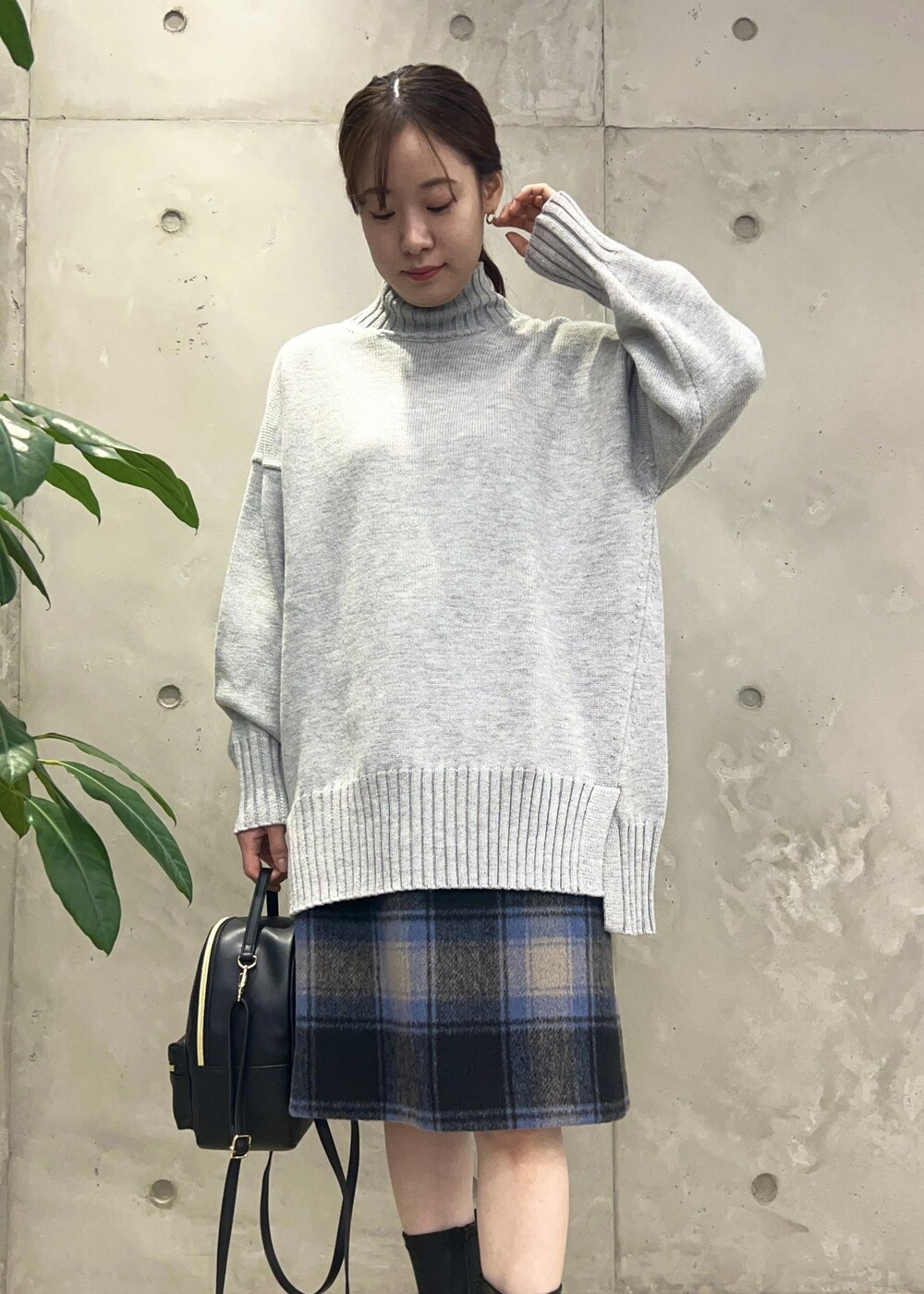 ブラック系のバックパック/リュック、グレー系のニット/セーター、ブラック系のブーツを着用したレディースの秋コーディネートの4枚目の写真