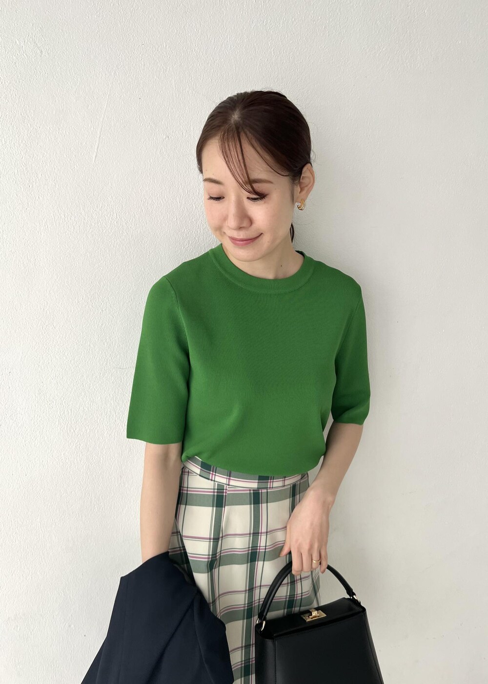 ブルー系のテーラードジャケット、グリーン系のスカート、グリーン系のニット/セーターを着用したレディースの春コーディネートの3枚目の写真