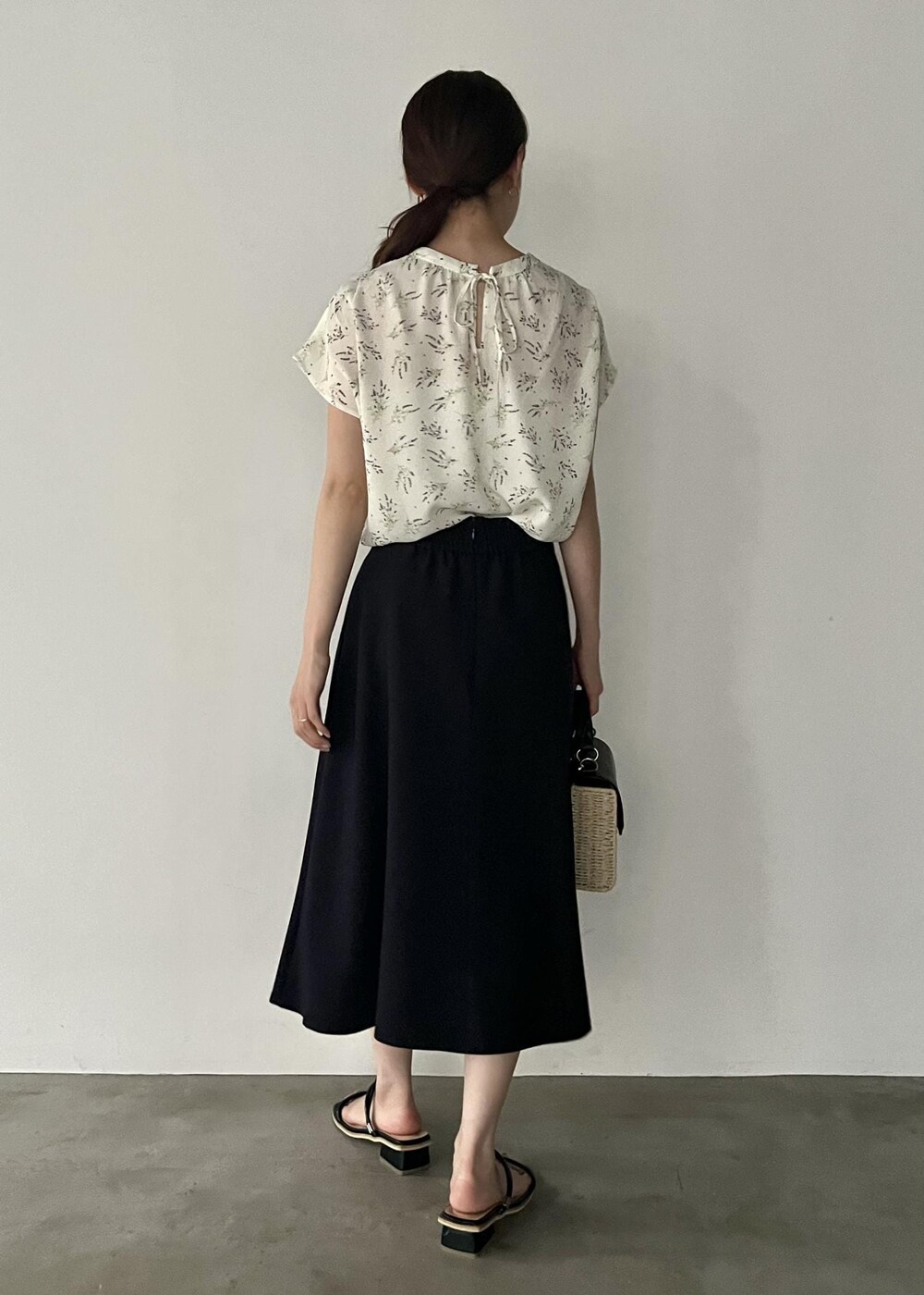 ブラック系のショルダーバッグ、ブラック系のサンダル、ブルー系のスカートを着用したレディースの夏コーディネートの3枚目の写真