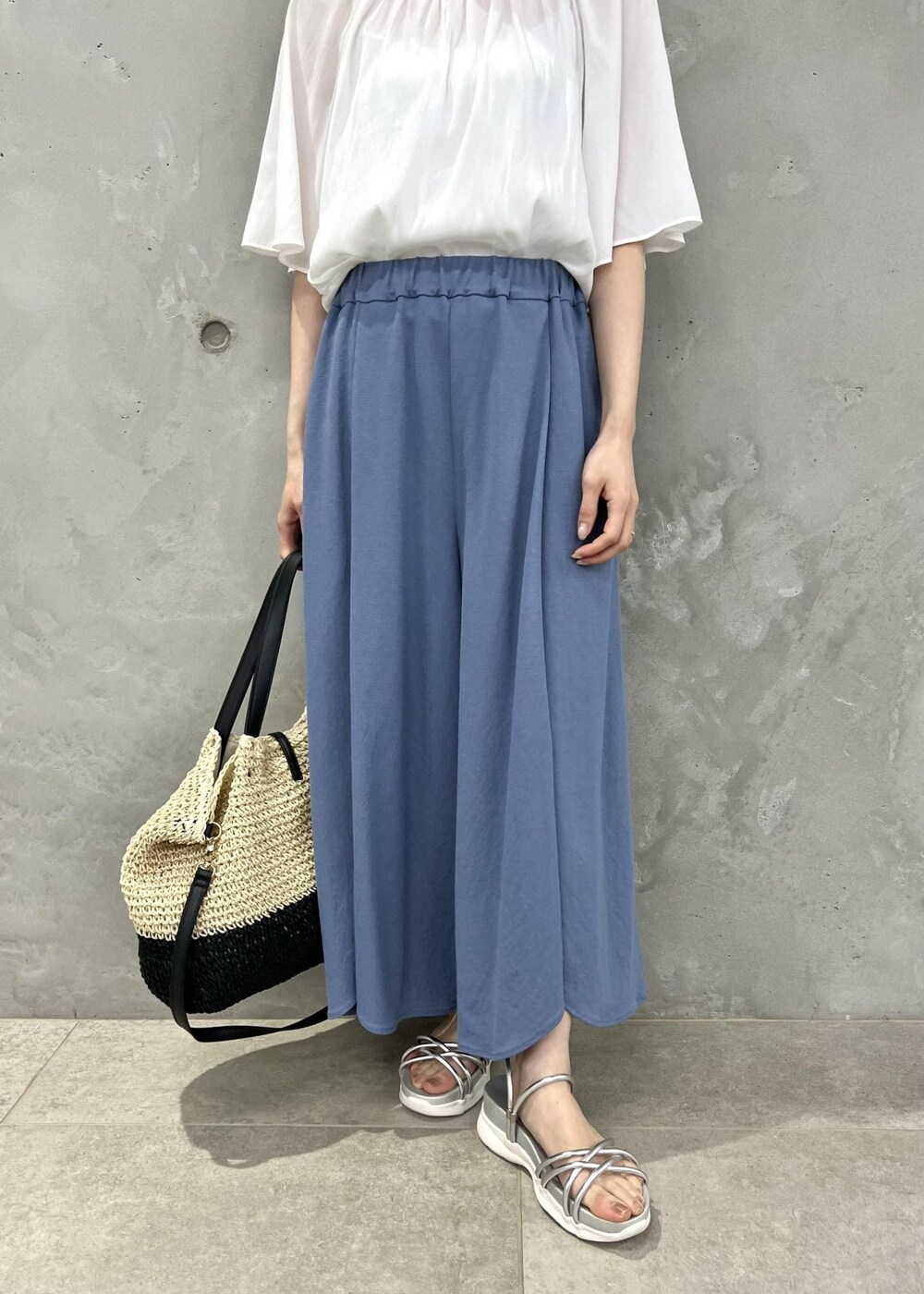 ブラック系のトートバッグ、シルバー系のサンダル、ホワイト系のシャツ/ブラウスを着用したレディースの夏コーディネートの5枚目の写真