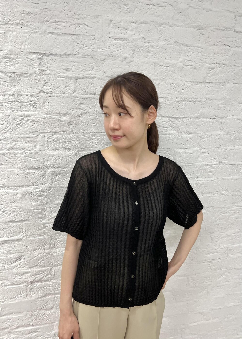 ブラック系のローファー、ブラック系のショルダーバッグ、ベージュ系のスラックスを着用したレディースの夏コーディネートの4枚目の写真