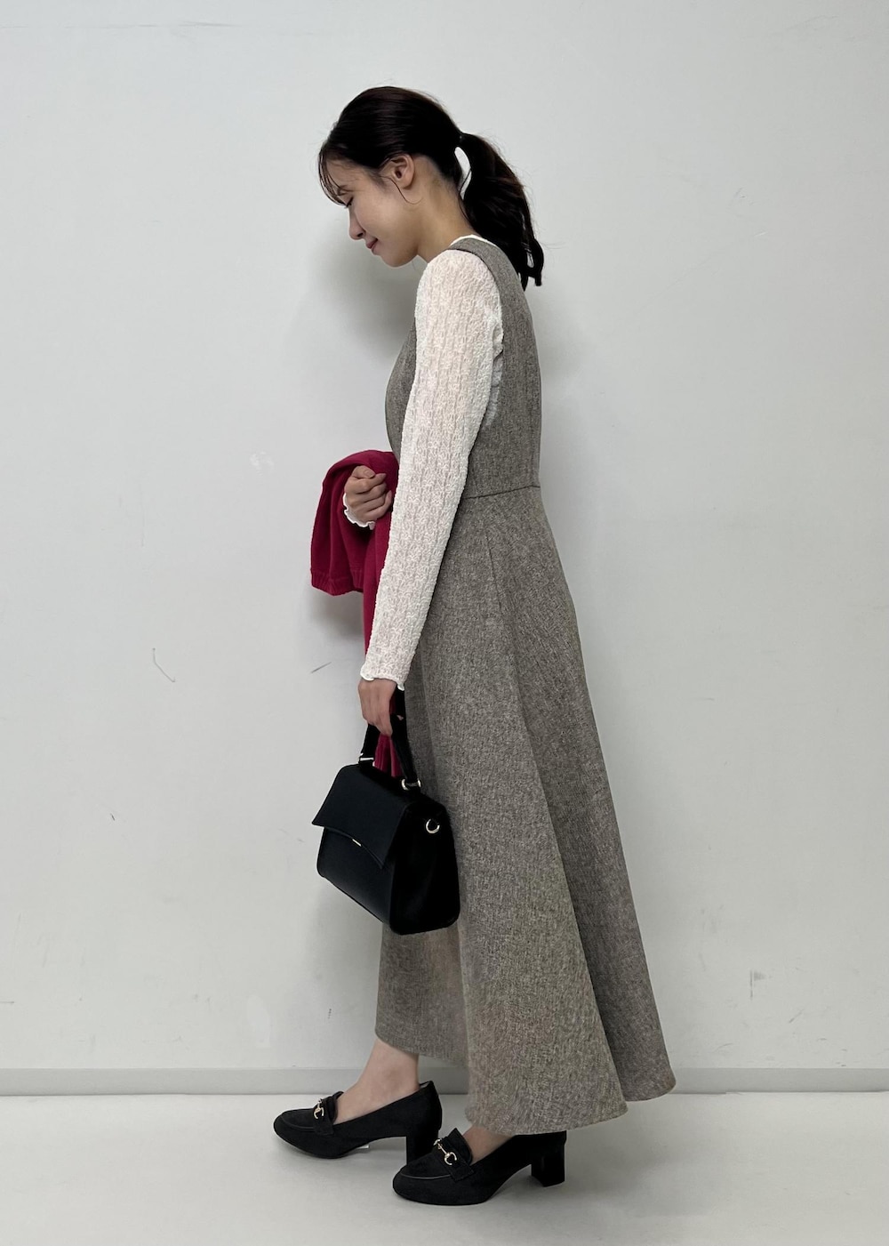 ベージュ系のジャンパースカート、ピンク系のカーディガン/ボレロ、ホワイト系のTシャツ/カットソーを着用したレディースの秋コーディネートの2枚目の写真