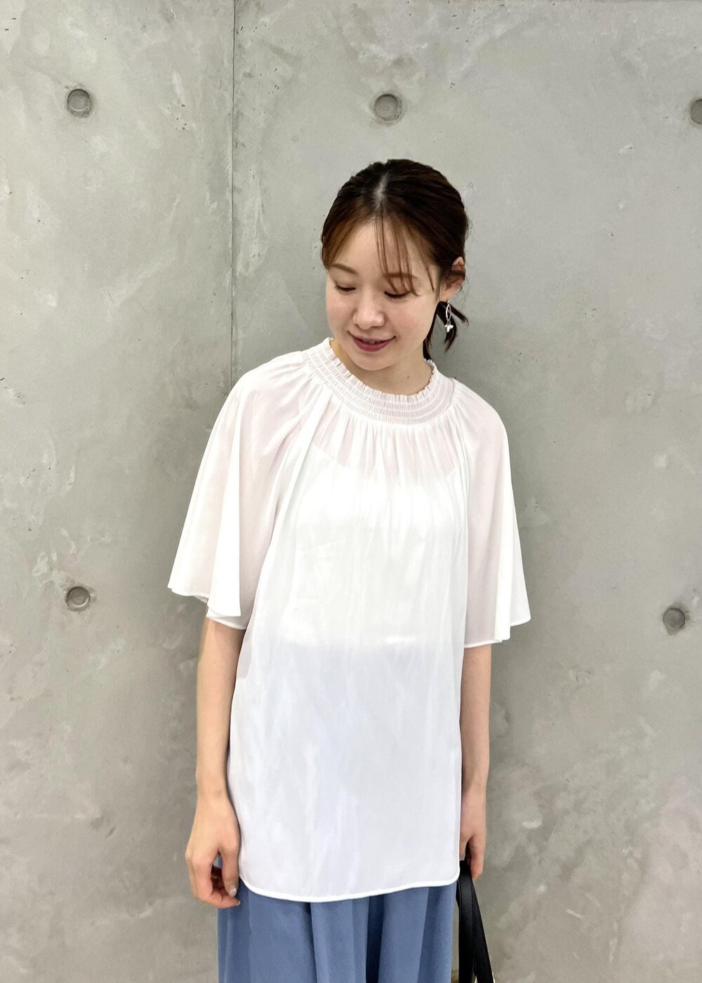 ブラック系のトートバッグ、シルバー系のサンダル、ホワイト系のシャツ/ブラウスを着用したレディースの夏コーディネートの4枚目の写真