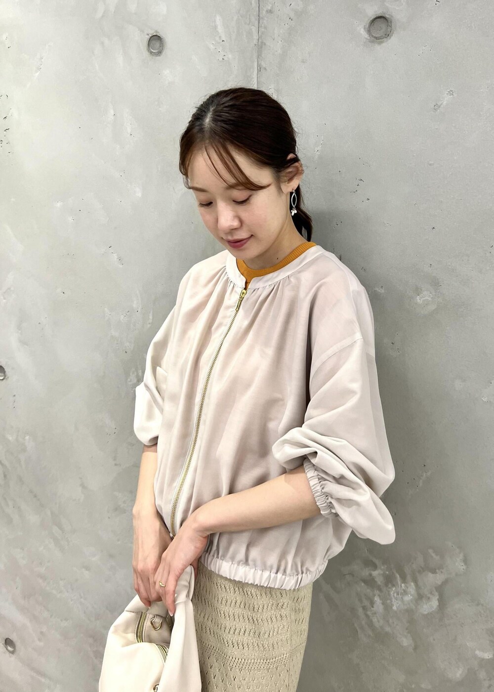 ベージュ系のサンダル、ベージュ系のブルゾン、オレンジ系のニット/セーターを着用したレディースの春コーディネートの8枚目の写真