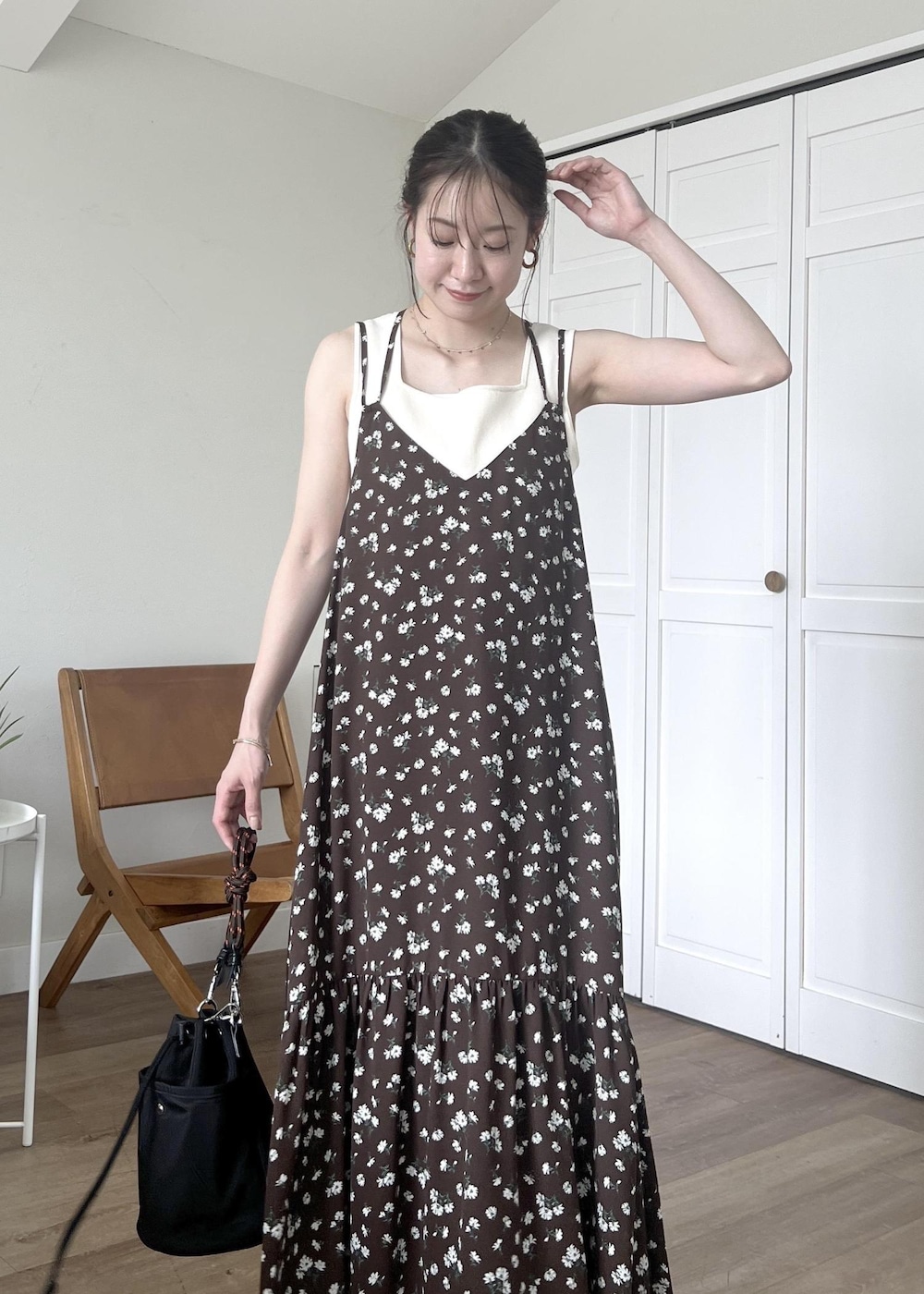 ブルー系のデニムパンツ、ブラック系のショルダーバッグ、ホワイト系のタンクトップを着用したレディースの春コーディネートの7枚目の写真