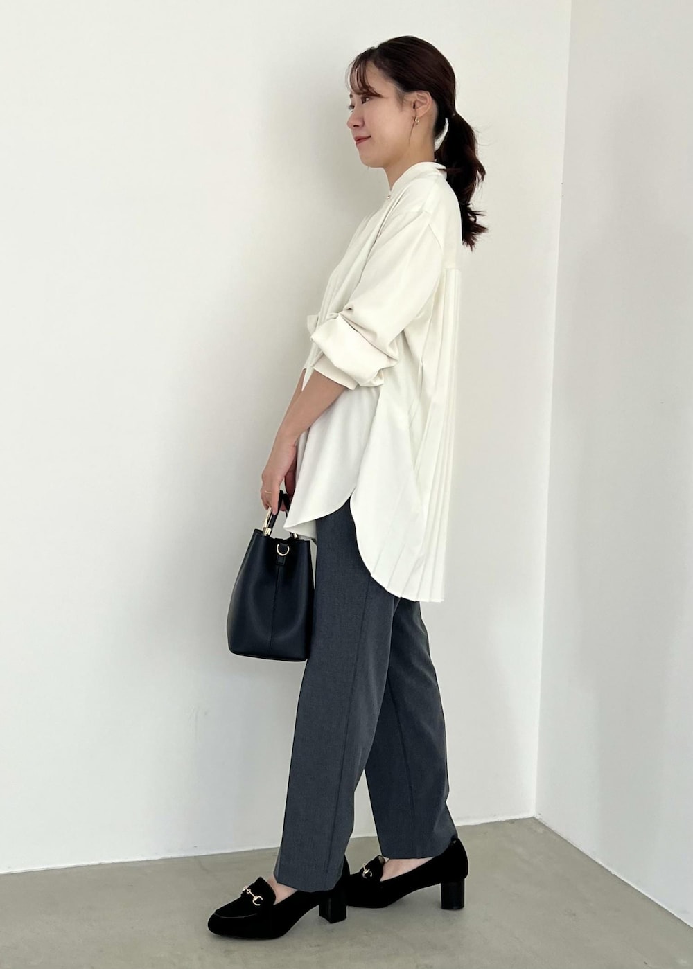 ブラック系のローファー、ブラック系のショルダーバッグ、グレー系のその他パンツを着用したレディースの冬コーディネートの2枚目の写真