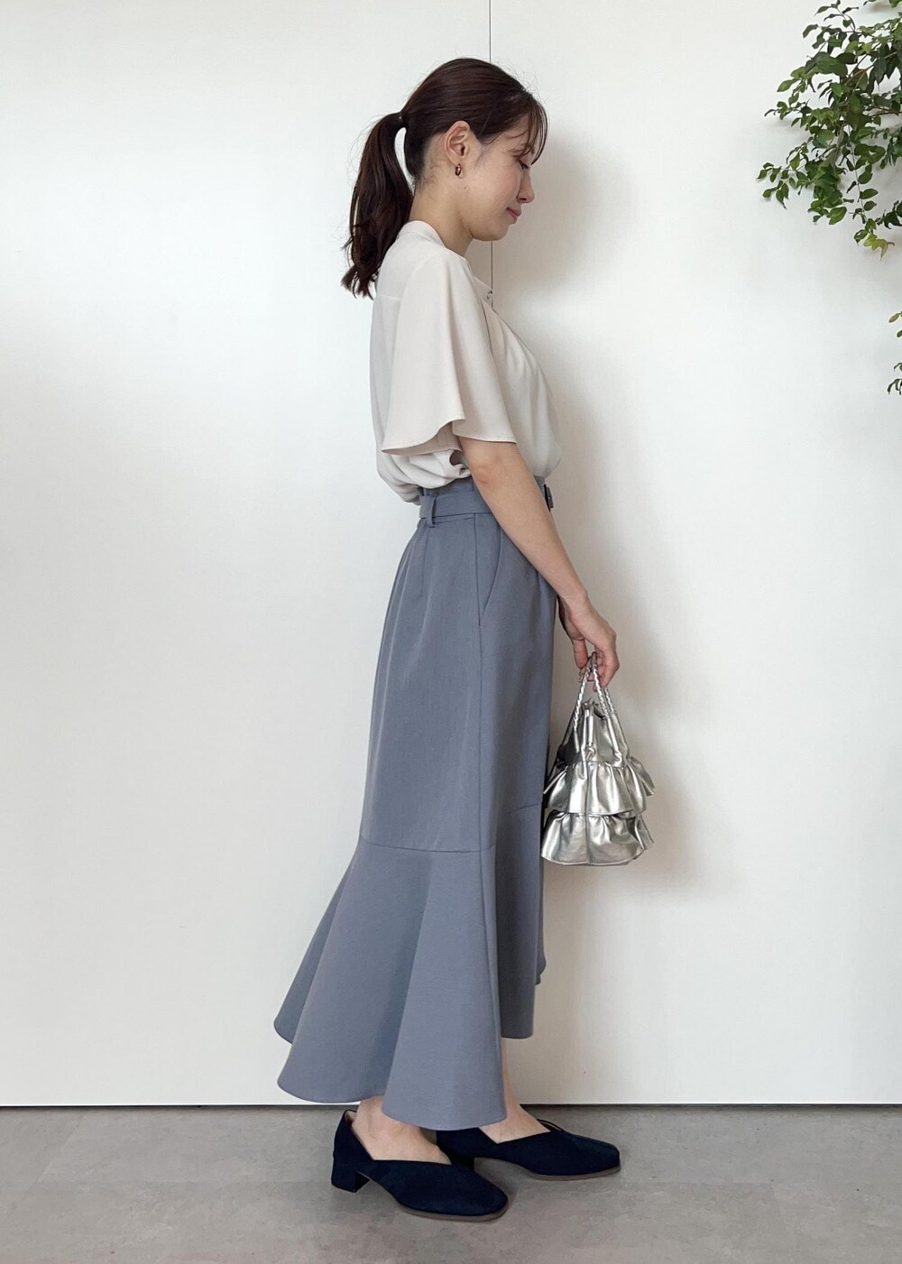 グレー系のシャツ/ブラウス、ブルー系のパンプス、シルバー系のショルダーバッグを着用したレディースの夏コーディネートの2枚目の写真