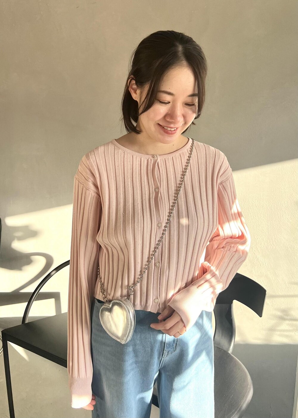 ピンク系のカーディガン/ボレロ、ブルー系のデニムパンツ、ブラック系のパンプスを着用したレディースの冬コーディネートの4枚目の写真