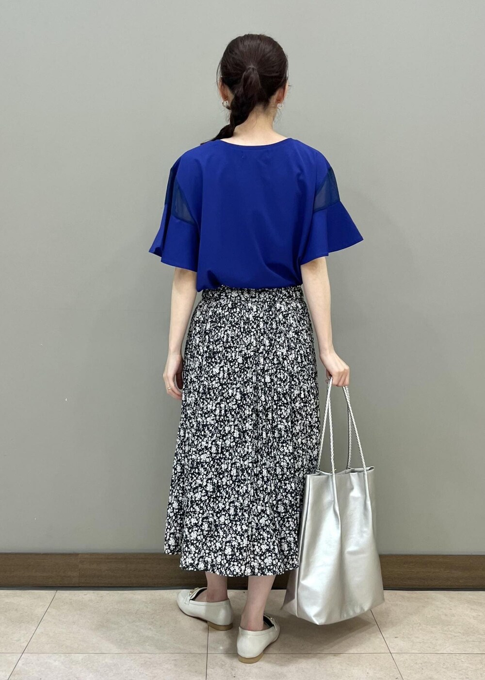 ホワイト系のローファー、シルバー系のトートバッグ、ブラック系のスカートを着用したレディースの夏コーディネートの3枚目の写真