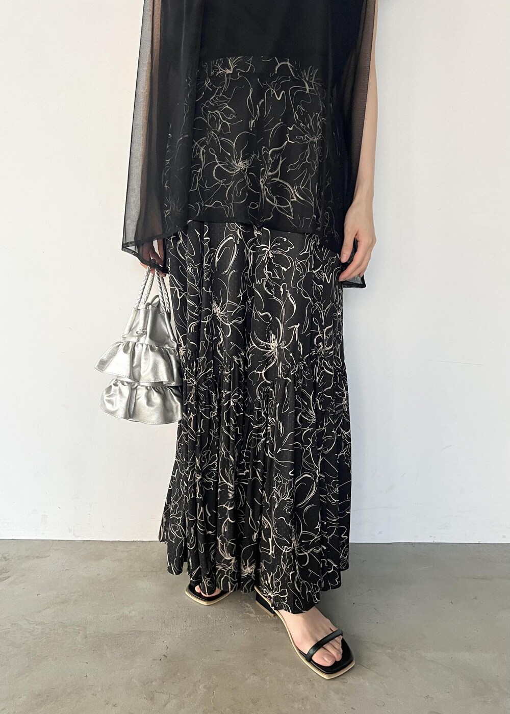 ブラック系のサンダル、ブラック系のTシャツ/カットソー、ブラック系のスカートを着用したレディースの夏コーディネートの6枚目の写真