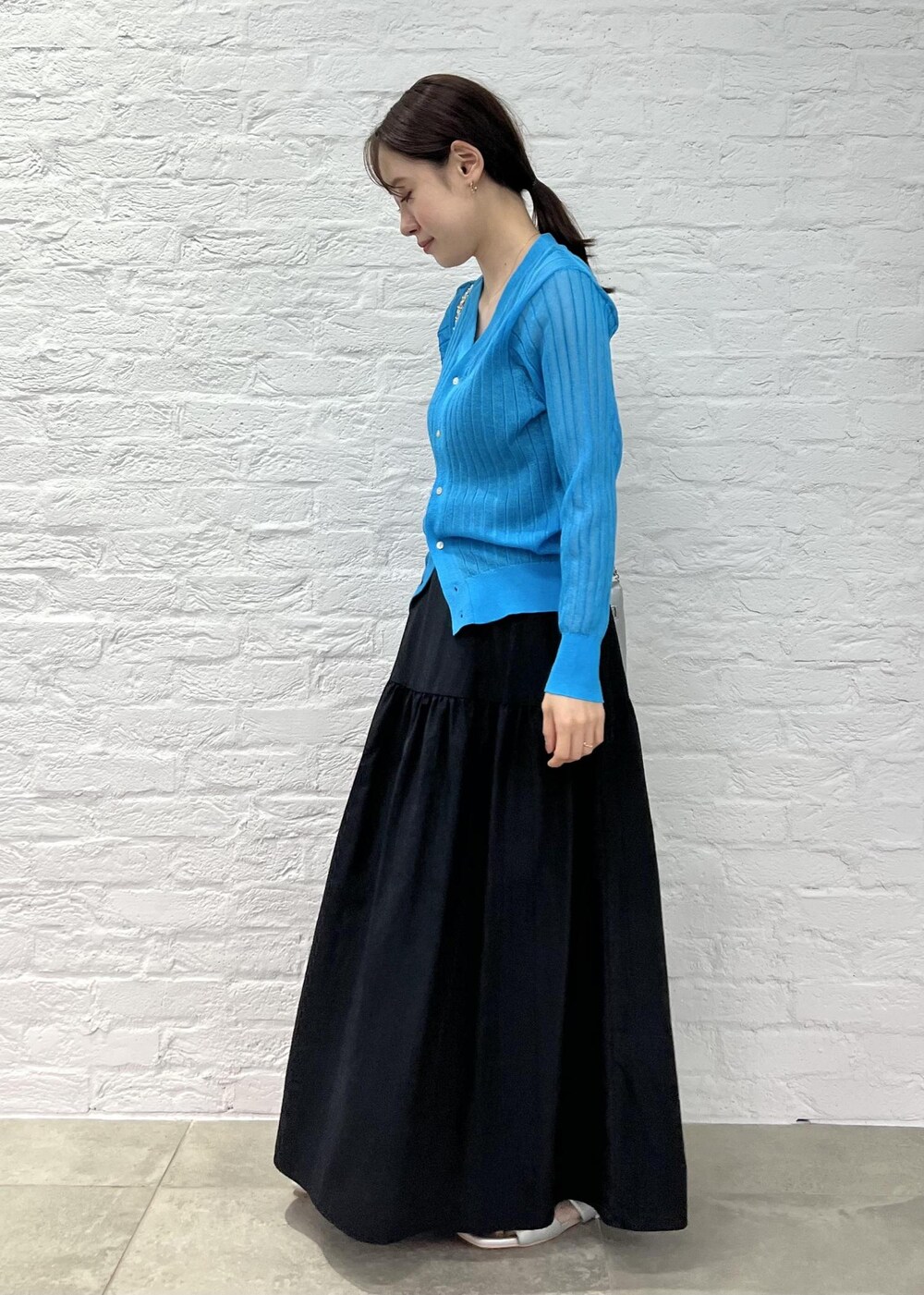 シルバー系のショルダーバッグ、シルバー系のサンダル、ブルー系のカーディガン/ボレロを着用したレディースの秋コーディネートの2枚目の写真