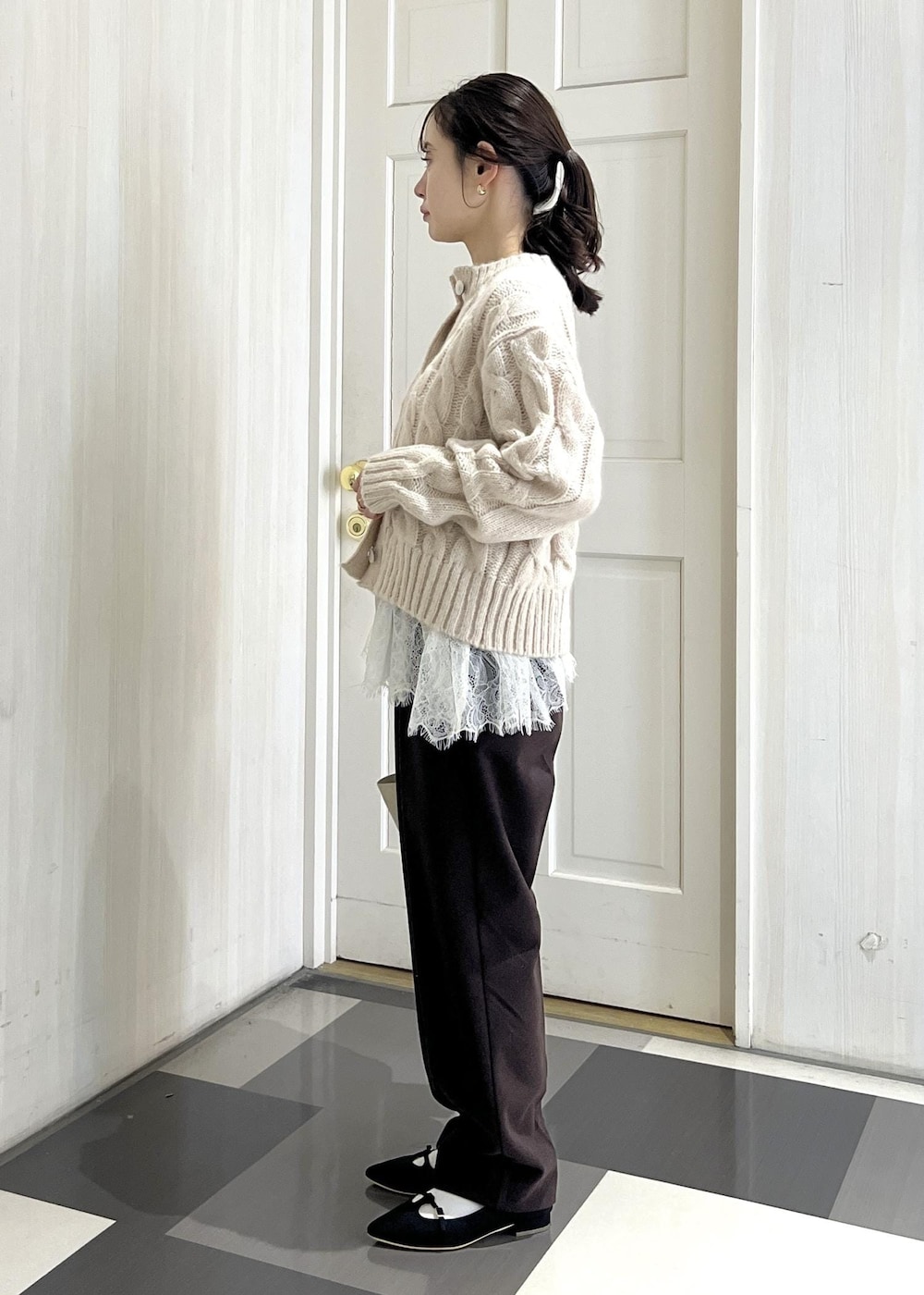 ブラック系のパンプス、ホワイト系のショルダーバッグ、ブラウン系のその他パンツを着用したレディースの冬コーディネートの2枚目の写真