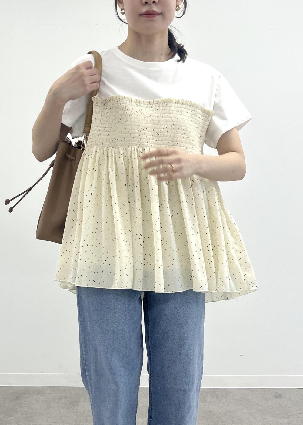 ブルー系のデニムパンツ、ブラウン系のショルダーバッグ、ブラック系のTシャツ/カットソーを着用したレディースの夏コーディネートの5枚目の写真