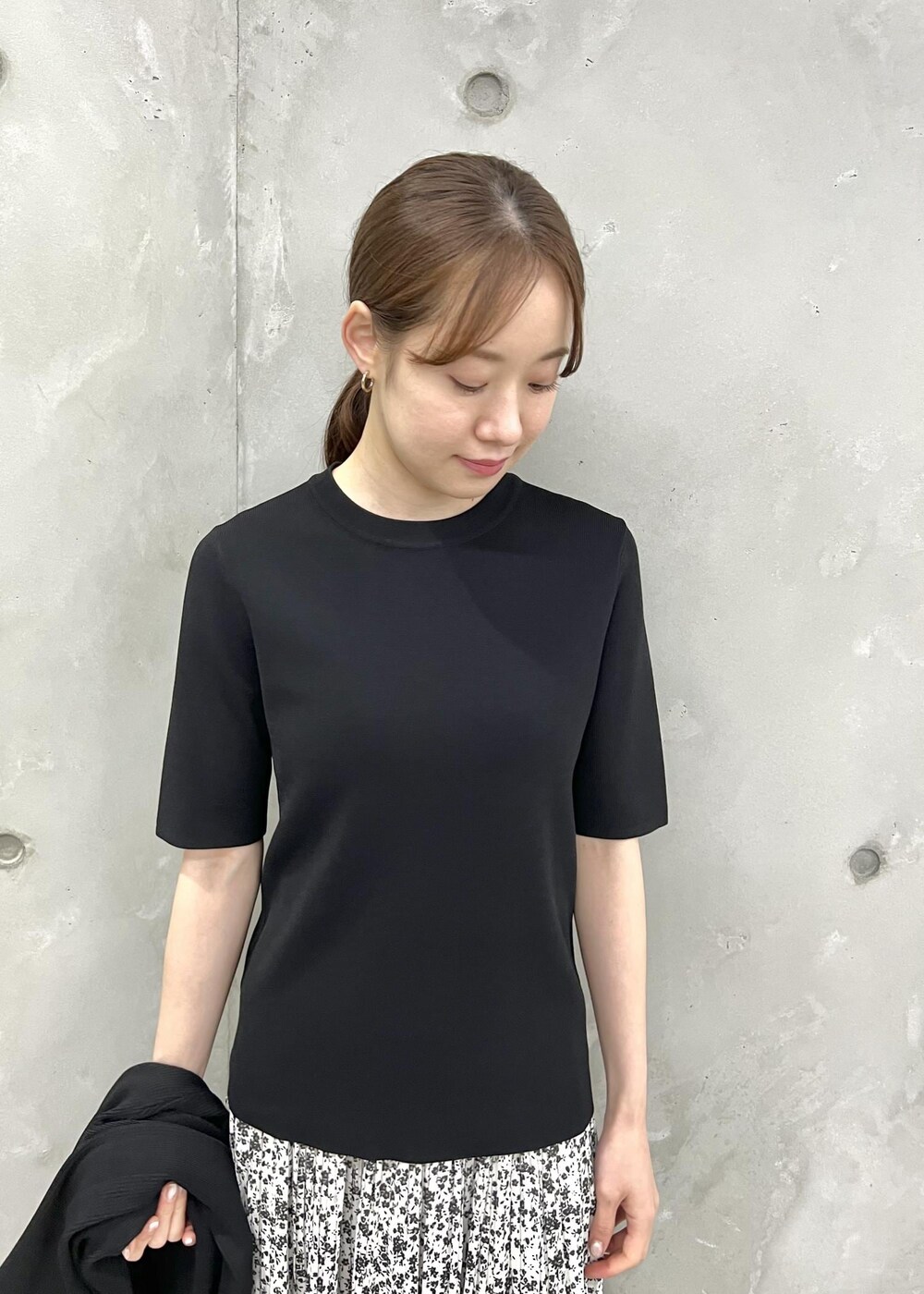 ブラック系のカーディガン/ボレロ、ホワイト系のスカート、ブラック系のニット/セーターを着用したレディースの春コーディネートの4枚目の写真