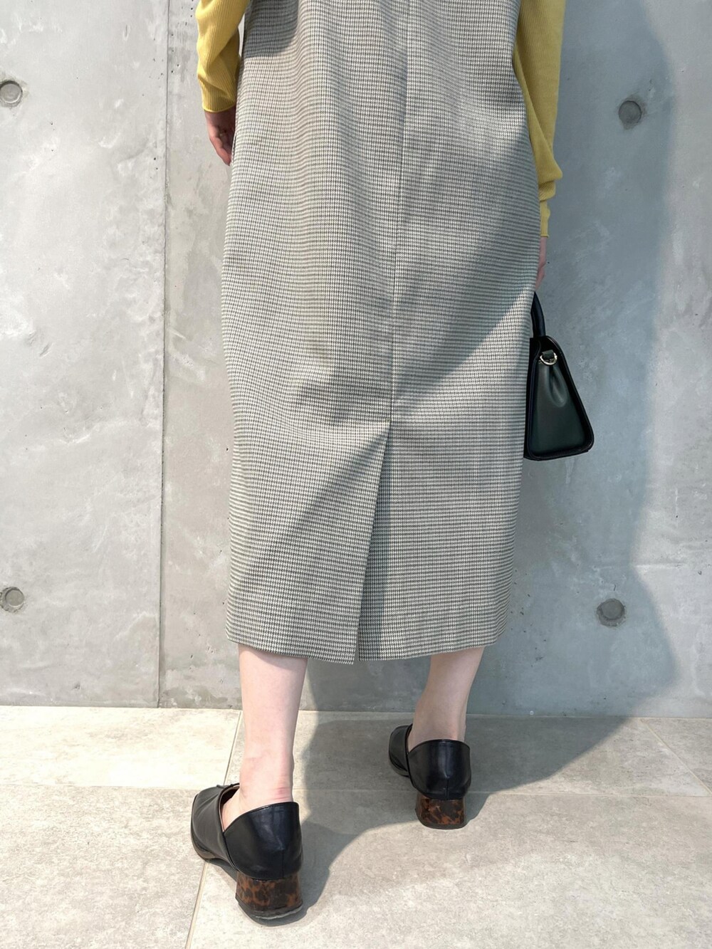 グリーン系のジャンパースカート、ブラック系のショルダーバッグ、ブラック系のその他シューズを着用したレディースの夏コーディネートの5枚目の写真