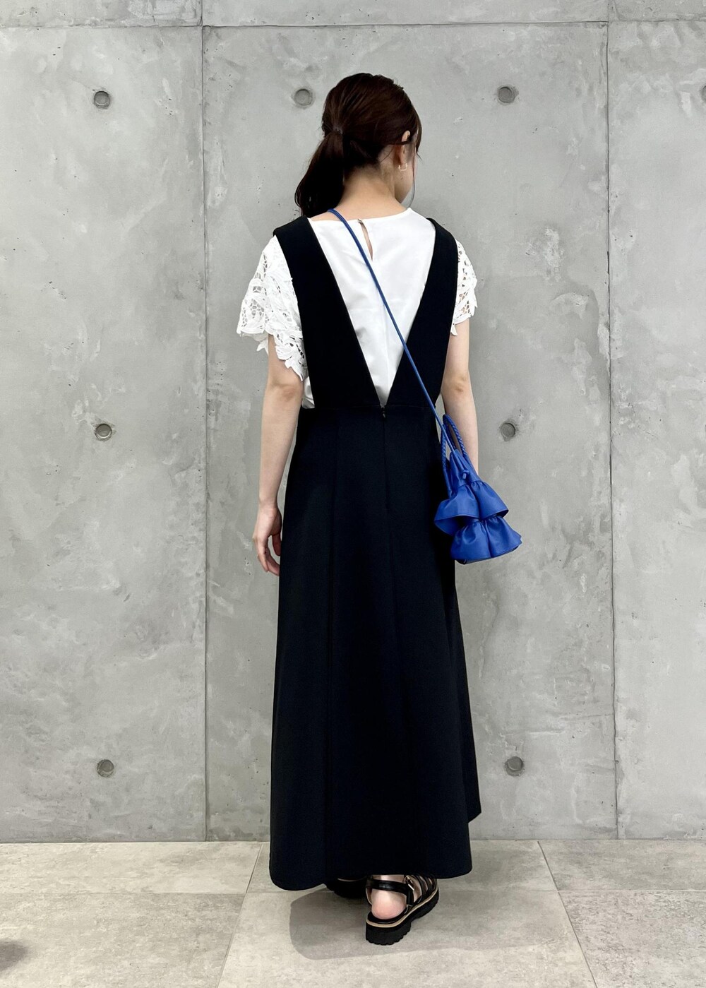 ブラック系のサンダル、ホワイト系のTシャツ/カットソー、ブルー系のショルダーバッグを着用したレディースの夏コーディネートの3枚目の写真