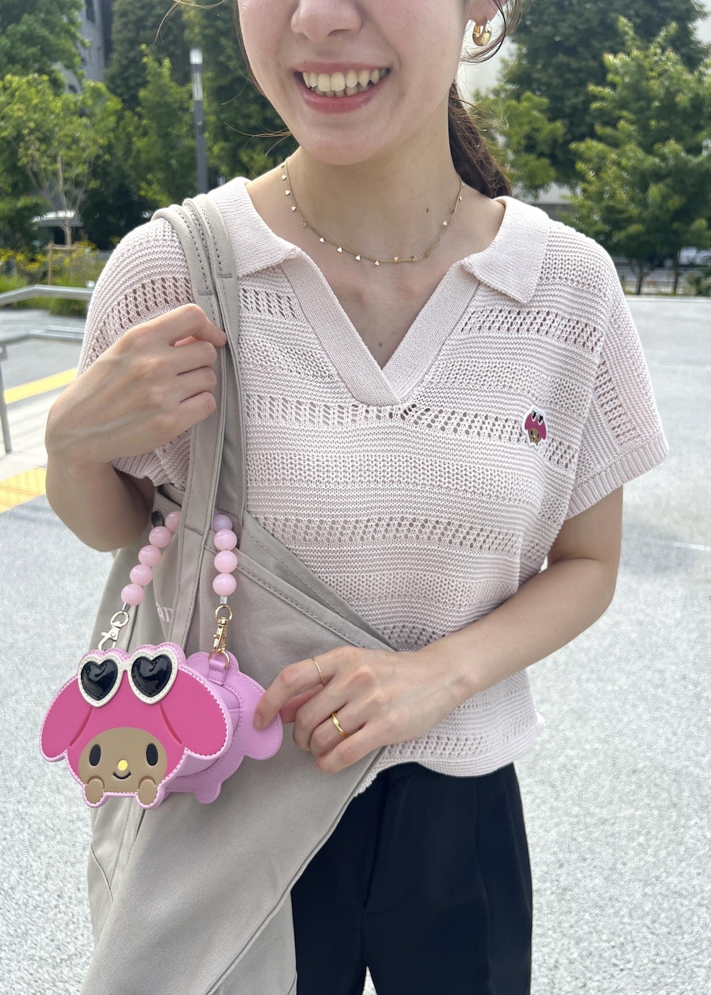 ピンク系のニット/セーター、ブラック系のその他パンツ、ピンク系のショルダーバッグを着用したレディースの夏コーディネートの5枚目の写真