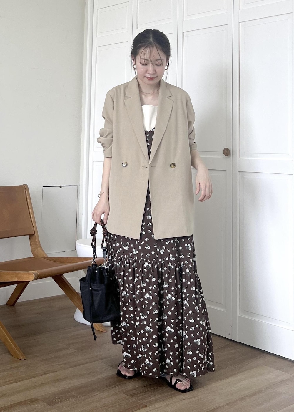 ブルー系のデニムパンツ、ブラック系のショルダーバッグ、ホワイト系のタンクトップを着用したレディースの春コーディネートの2枚目の写真