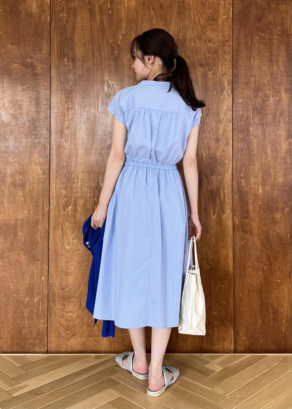 シルバー系のサンダル、ブルー系のカーディガン/ボレロ、ホワイト系のトートバッグを着用したレディースの夏コーディネートの5枚目の写真