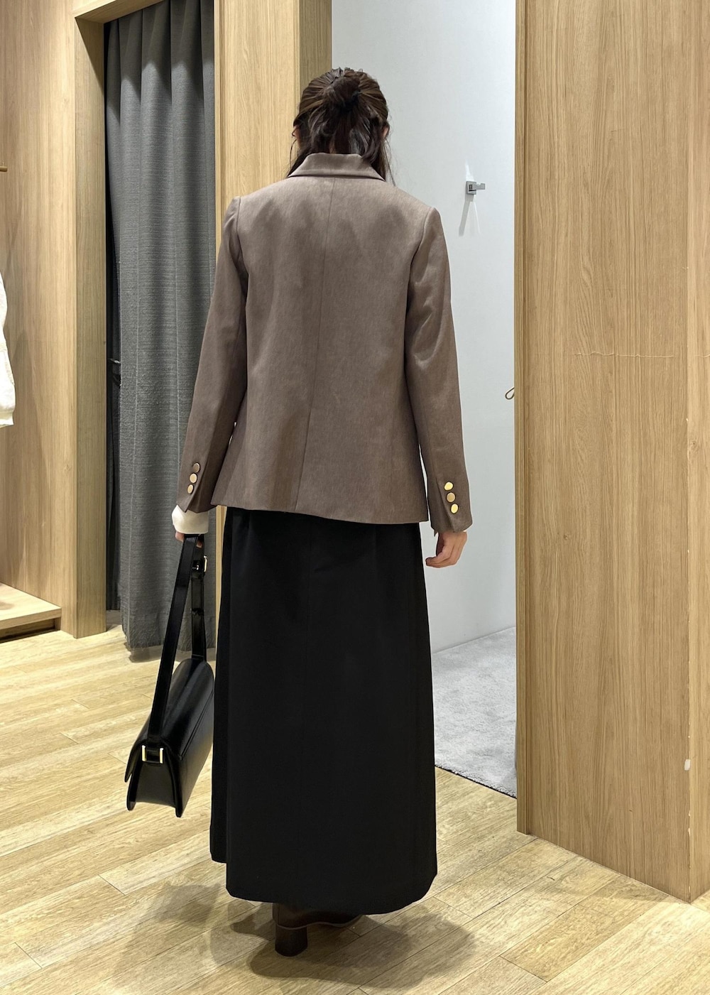 ブラック系のショルダーバッグ、ホワイト系のニット/セーター、ブラック系のワンピースを着用したレディースの秋コーディネートの4枚目の写真