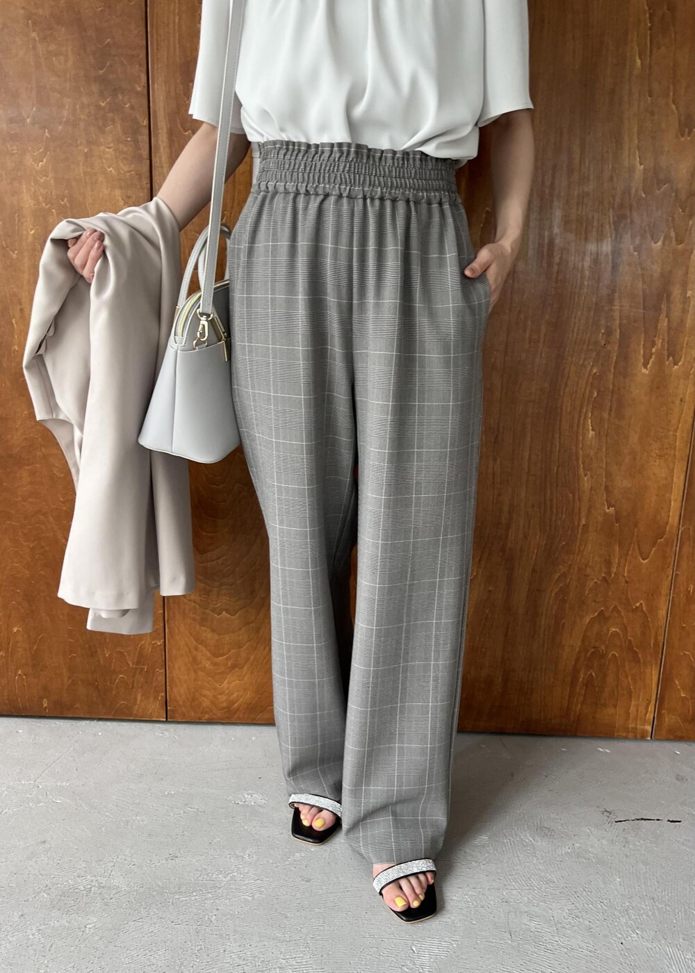 ブラック系のサンダル、ベージュ系のジャンパースカート、ホワイト系のシャツ/ブラウスを着用したレディースの夏コーディネートの6枚目の写真