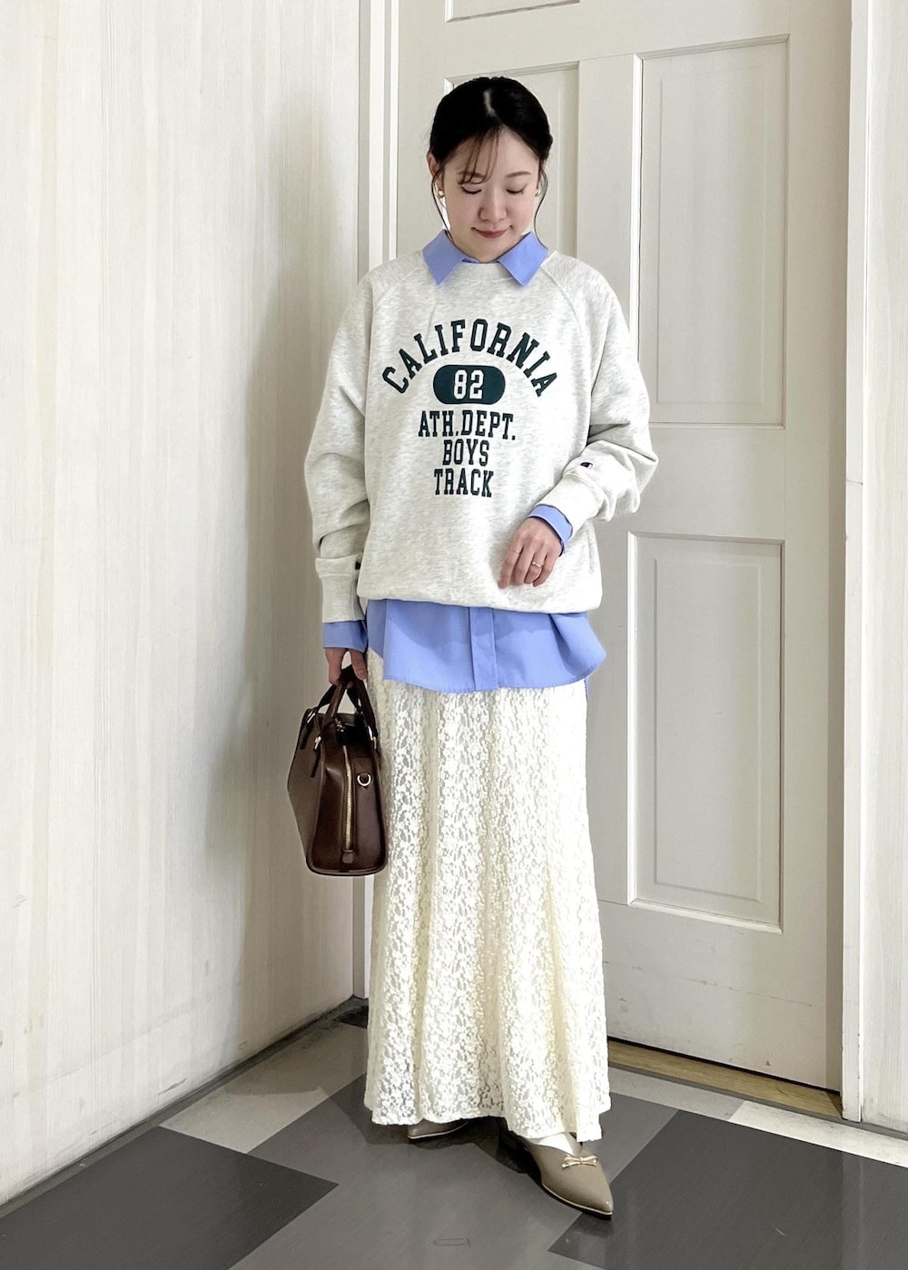 ブラウン系のボストンバッグ、ベージュ系のパンプス、ホワイト系のスウェットを着用したレディースの冬コーディネートの8枚目の写真